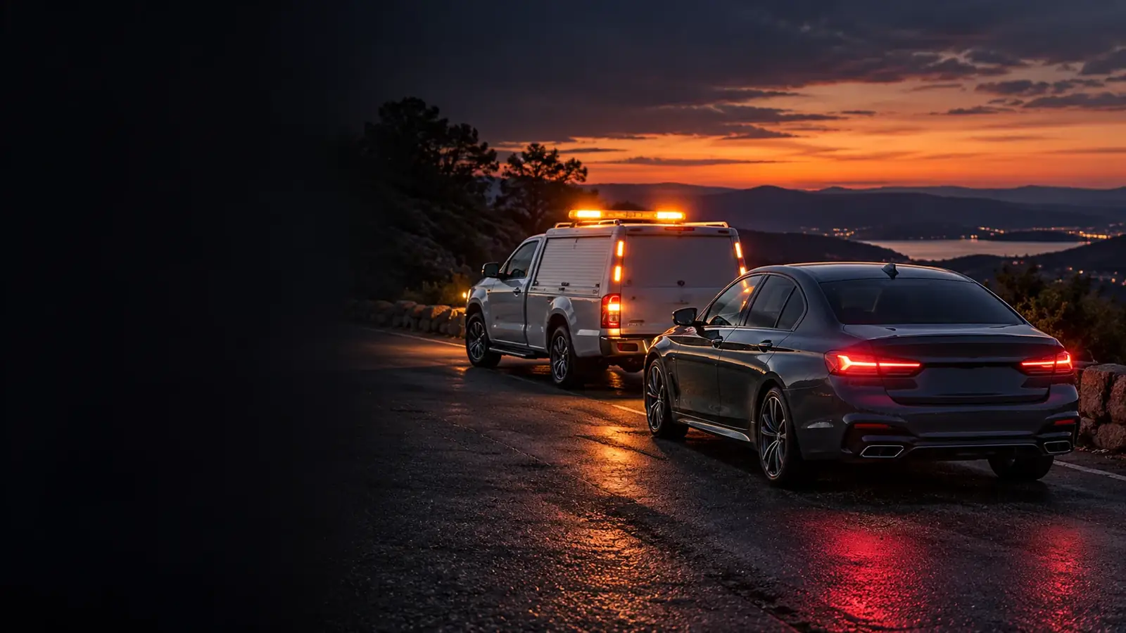 unbranded roadside assistance vehicle and dark sedan parked safely in a roadside lay-by at dusk